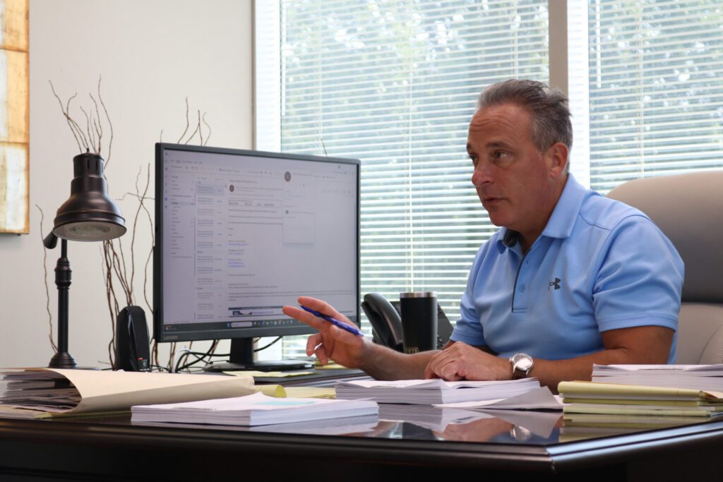 Attorney Christopher A. Vallano talking at his desk.